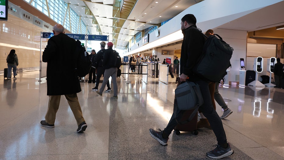 Flight restrictions slashed at 40 major US airports as government reopens, staffing improves 5 Passengers travel through a terminal at Ronald Reagan Washington National Airport.