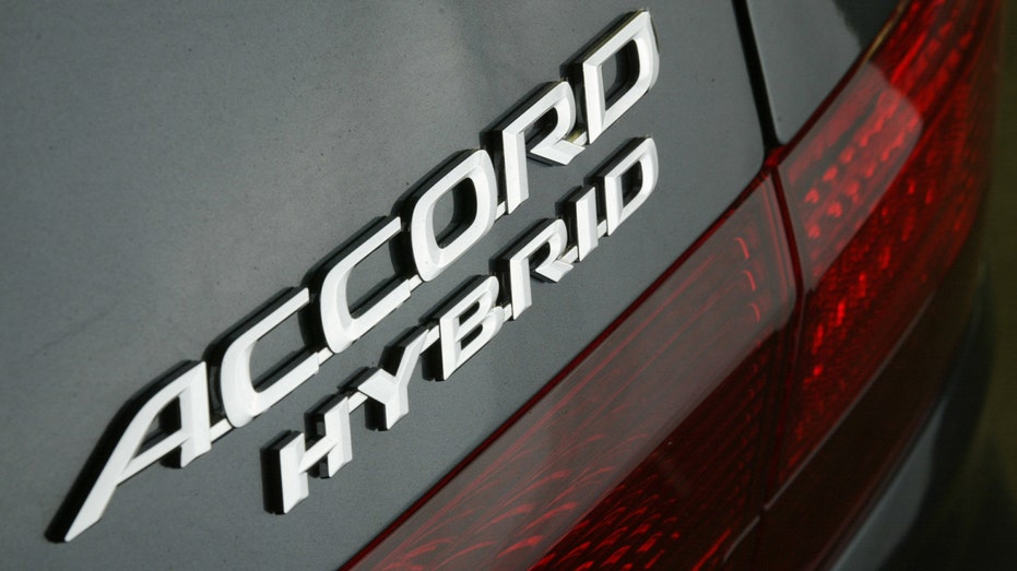 Logo of Honda Accord hybrid on back of car.