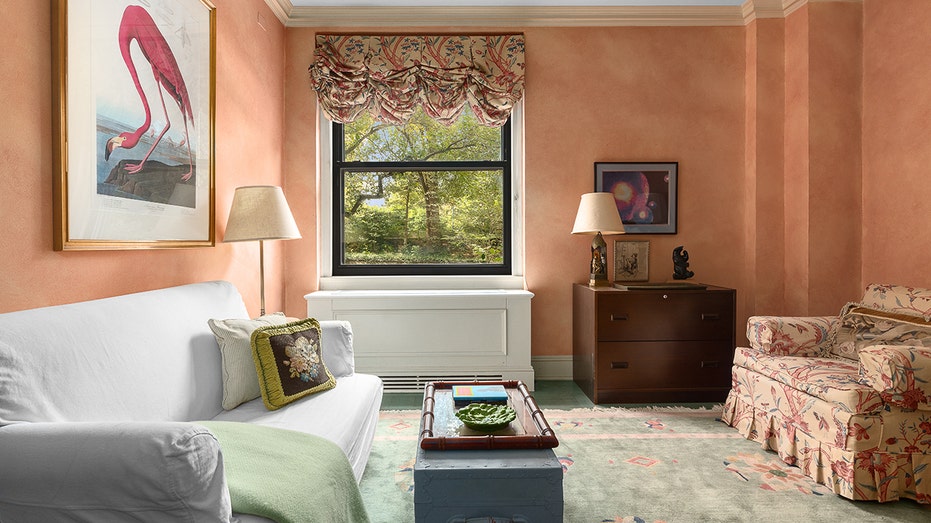 Paul Newman and Joanne Woodward's New York apartment hits market for first time in 40 years for $1.69M 13 A sitting room with pink walls and a window looking out.